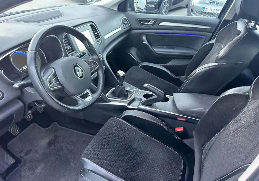 Intérieur de Renault Mégane IV TCe 130 Energy Intens 2016, vue côté conducteur, volant cuir et sièges tissu noir.
