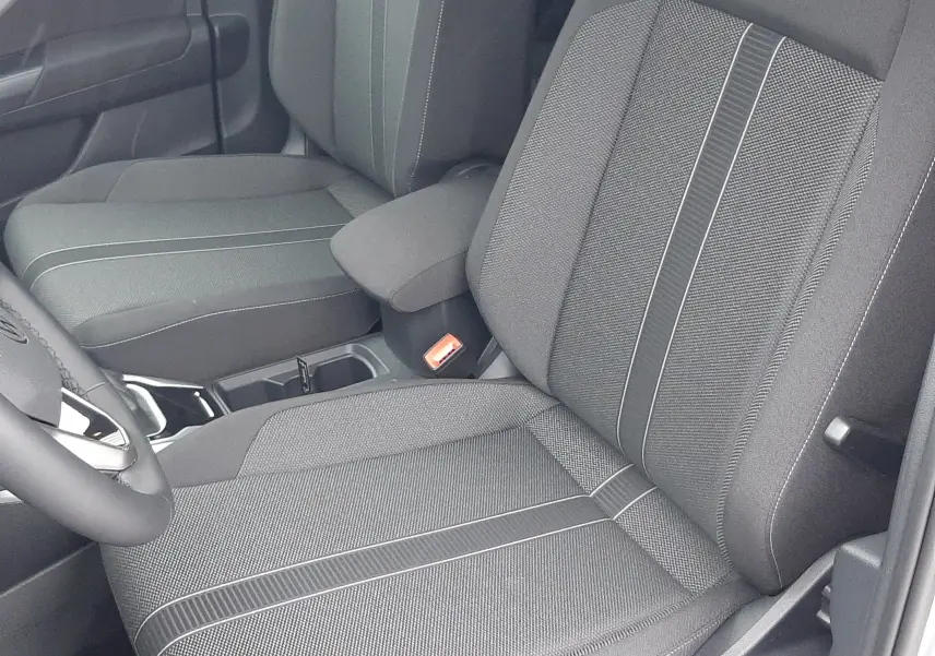 Vue rapprochée des sièges avant en tissu noir avec surpiqûres grises du Volkswagen T-Roc gris Pyrite 2025.