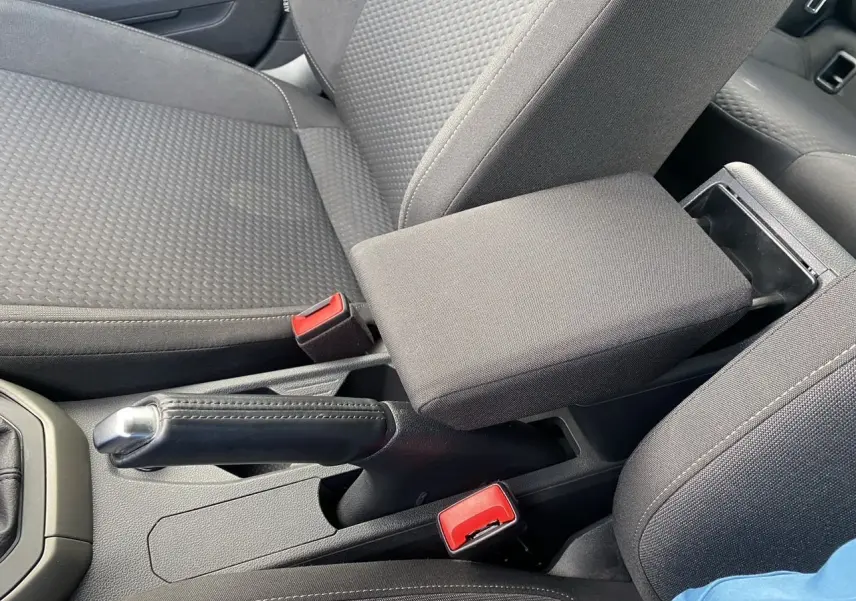 Gros plan sur l'accoudoir central et les sièges en tissu noir de l'intérieur d'une Volkswagen Polo 2020.