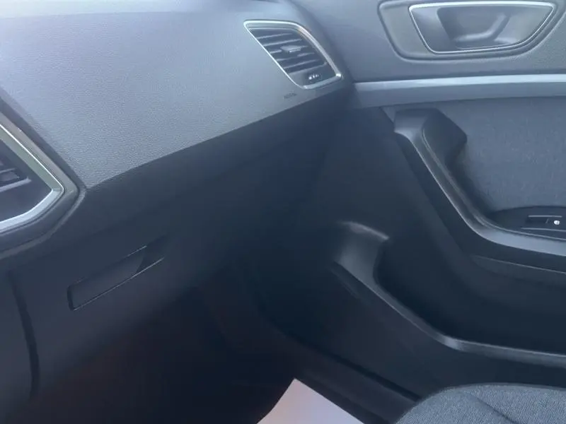 Intérieur côté passager du SEAT Ateca 2022, avec tableau de bord noir et garnitures de porte sombres.