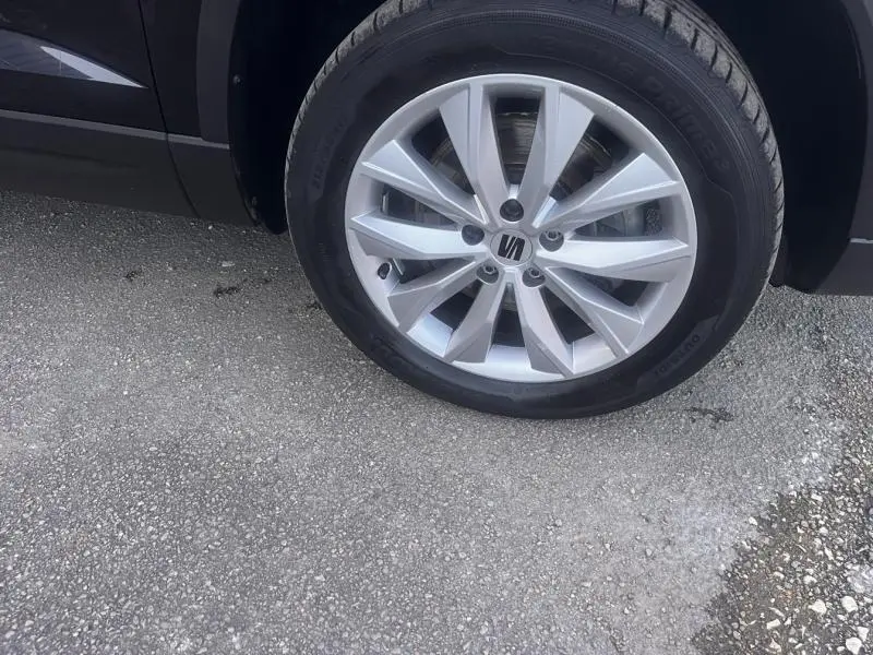 Gros plan sur la roue avant droite avec jante alliage argentée du SEAT Ateca noir Magique Métal.