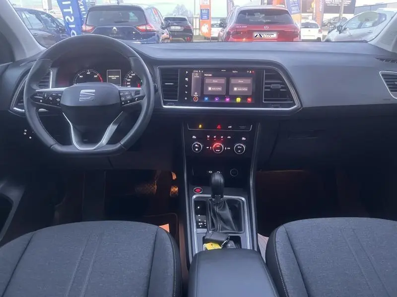 Vue intérieure avant du tableau de bord et volant cuir noir du SEAT Ateca 2022 avec écran tactile et console centrale.
