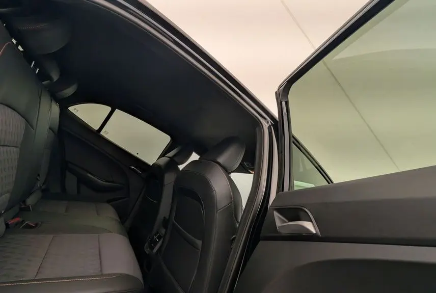 Vue intérieure côté gauche montrant les sièges arrière en similicuir noir avec surpiqûres orange du MG3 Pebble Black 2026.