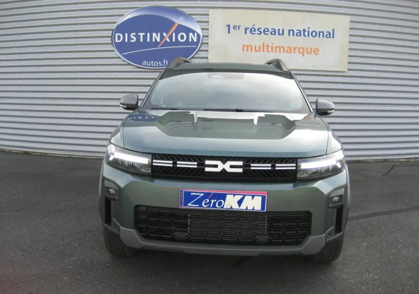 Vue de face du Dacia Bigster gris schiste 2026 avec calandre noire et phares LED allumés.