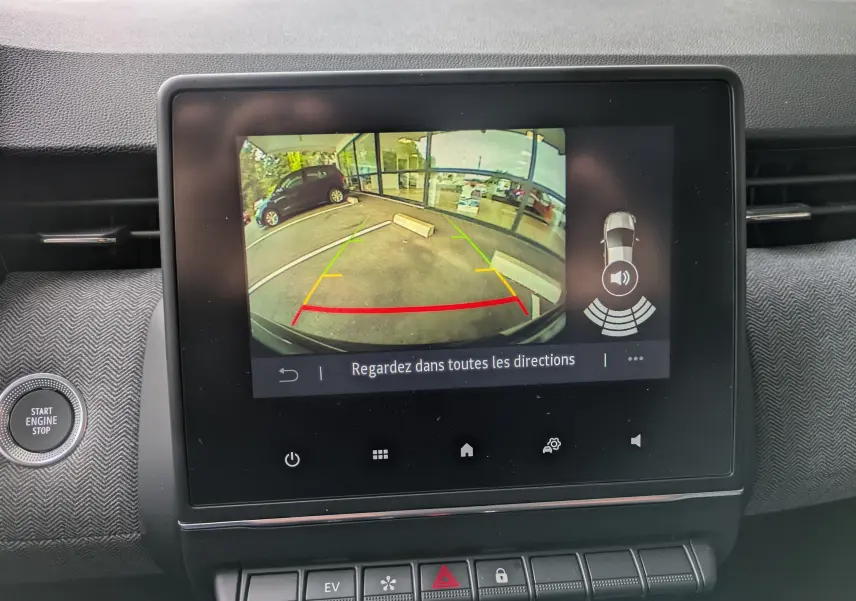 Écran central montrant la caméra de recul avec vue arrière du parking, dans une Renault Clio noire étoile métal 2025.