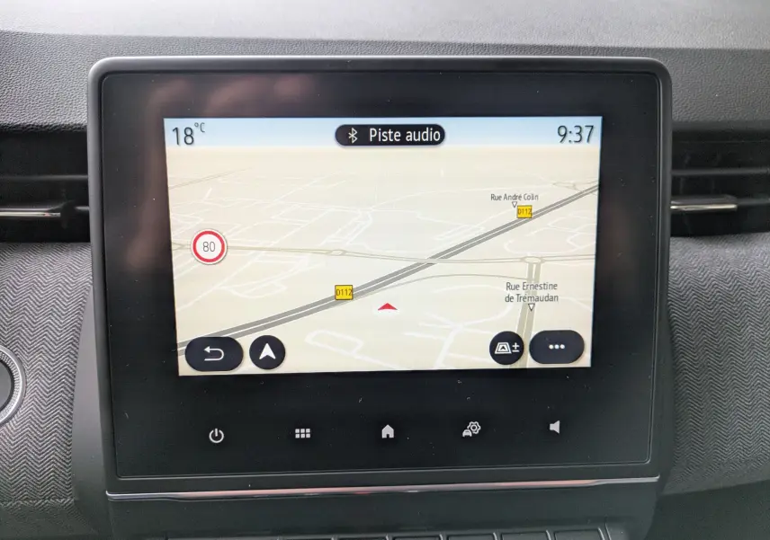 Écran tactile central de la Renault Clio 2025 noir étoile métal affichant la navigation avec carte et indications routières.