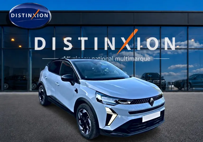 Renault Captur 2026 gris rafale en 3/4 avant, avec toit noir et jantes alu distinctives, devant showroom Distinxion.
