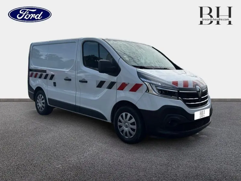 Renault Trafic Fourgon blanc Glacier en 3/4 avant droit avec marquages rouges et noirs sur la carrosserie.
