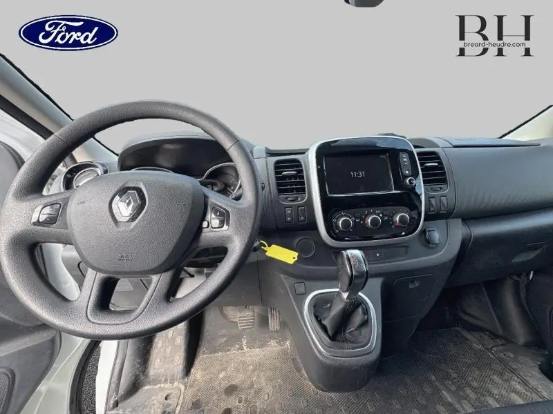 Vue intérieure du tableau de bord du Renault Trafic blanc, avec volant multifonction et écran central tactile.