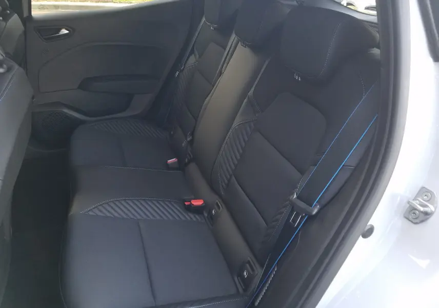 Vue intérieure côté droit sur les sièges arrière noirs avec surpiqûres bleues de la Renault Clio V gris Rafale 2025.