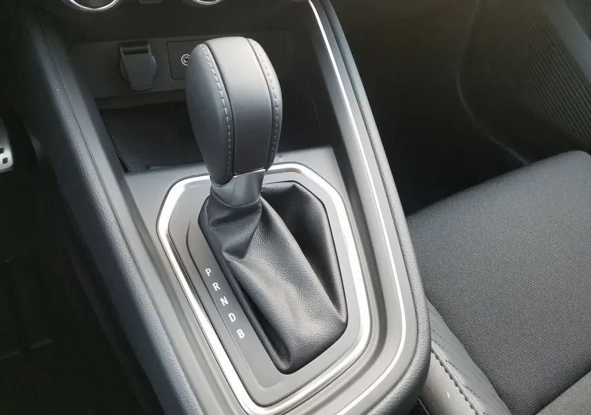 Le levier de boîte automatique en cuir noir de la Renault Clio V hybride, vue rapprochée de la console centrale.