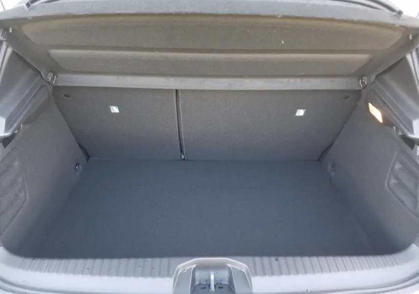 Coffre ouvert de la Renault Clio V hybride gris Rafale, montrant un espace de rangement propre et bien agencé.