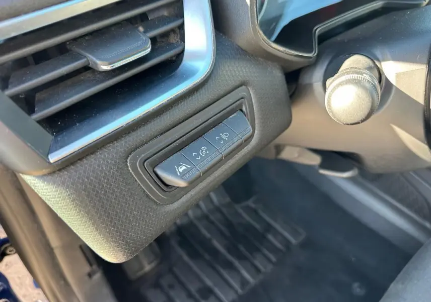 Gros plan sur les commandes d'aide à la conduite à gauche du volant d'une Renault Clio bleu foncé 2023.