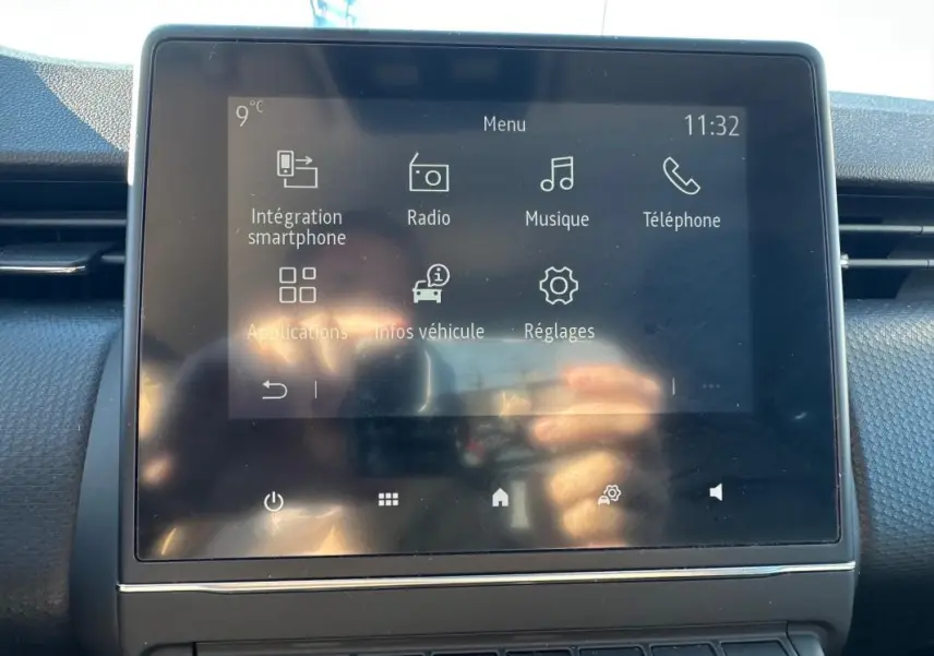 Écran tactile central de la Renault Clio bleu foncé 2023 affichant le menu multimédia intérieur.