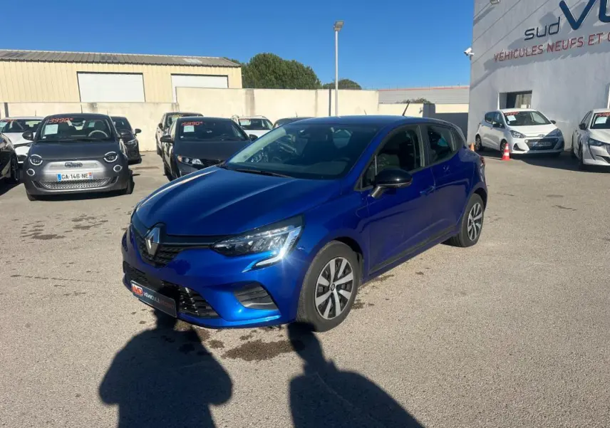 Renault Clio V TCe 90 bleu foncé vue 3/4 avant droit sur parking ensoleillé avec antenne requin visible