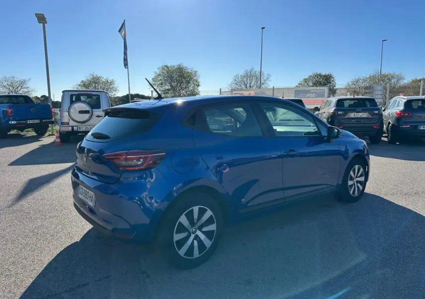 Renault Clio bleu foncé vue 3/4 arrière côté droit, avec antenne requin et feux arrière LED distinctifs.