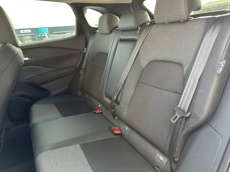Vue intérieure de la banquette arrière du Nissan Qashqai Hybrid e-POWER 2025, sièges tissu noir et gris avec ceintures de sécurité.