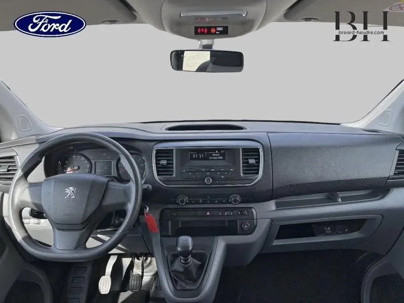 Vue intérieure avant du Peugeot Expert Fourgon blanc Banquise de 2017, avec tableau de bord et volant à gauche visibles.