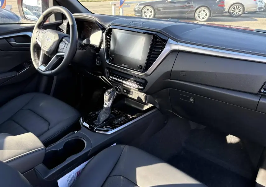 Intérieur du pick-up Isuzu D-MAX 2026, vue côté conducteur, tableau de bord moderne avec écran tactile et volant multifonctions.
