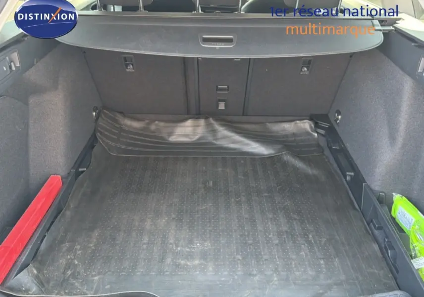 Coffre ouvert vu de l'arrière d'une Volkswagen Golf SW 2026 bleu Anemone, avec tapis de protection noir et rangements latéraux.