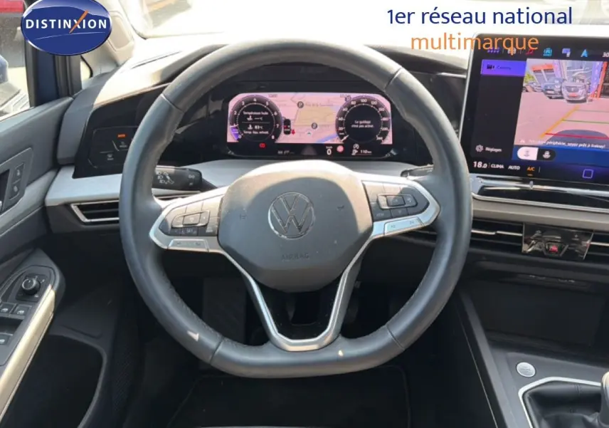 Vue intérieure centrée sur le volant et le tableau de bord numérique d'une Volkswagen Golf SW 2026, avec écran tactile et commandes au volant.