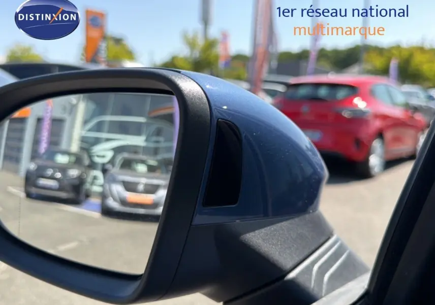 Rétroviseur côté gauche bleu Anemone de la Volkswagen Golf SW 2026, avec reflet de voitures en arrière-plan.