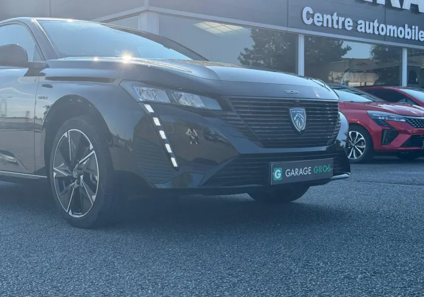 Peugeot e-308 noir Perla Nera vue 3/4 avant gauche, avec feux LED verticaux et jantes alu distinctives.