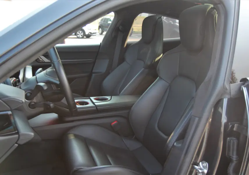 Intérieur noir cuir du Porsche Taycan Turbo 2020 vu côté conducteur, avec sièges sport et console centrale visible.