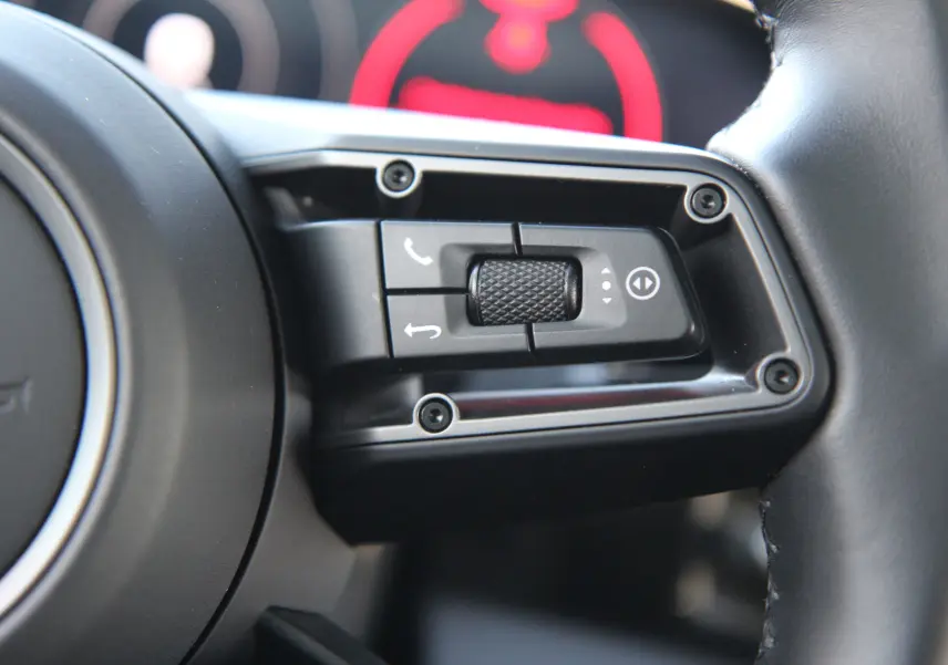 Gros plan sur les commandes multifonctions noires à droite du volant cuir du Porsche Taycan Turbo gris anthracite 2020.