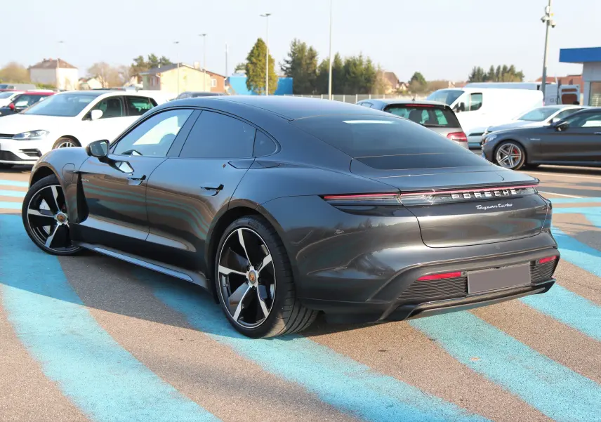 Porsche Taycan Turbo gris anthracite vue 3/4 arrière droit avec jantes exclusives et toit panoramique.