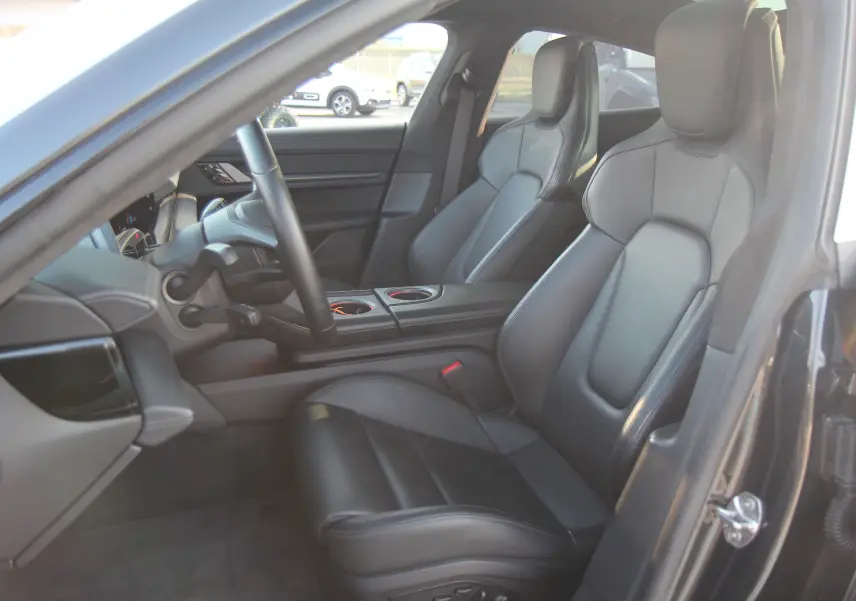 Intérieur avant droit de la Porsche Taycan Turbo gris anthracite avec sièges sport en cuir noir et console centrale.