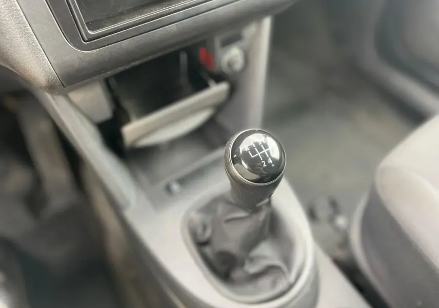 Le levier de vitesses manuel en gros plan dans l'habitacle du Volkswagen Caddy blanc, avec console centrale visible floue.
