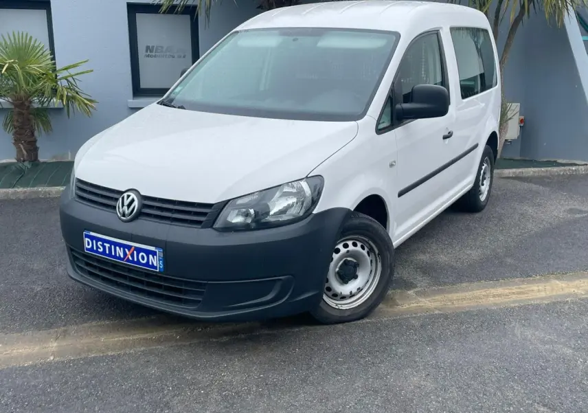 Volkswagen Caddy blanc Candy en 3/4 avant droit, avec pare-chocs noir et jantes acier simples.