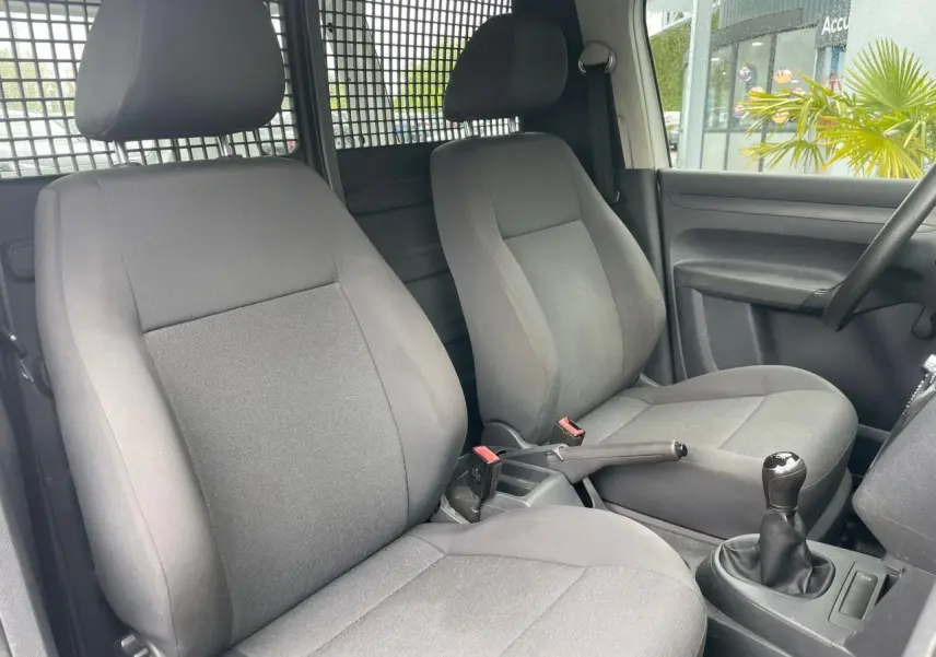 Intérieur du Volkswagen Caddy Van 2014 montrant les sièges avant gris et la boîte manuelle côté droit.