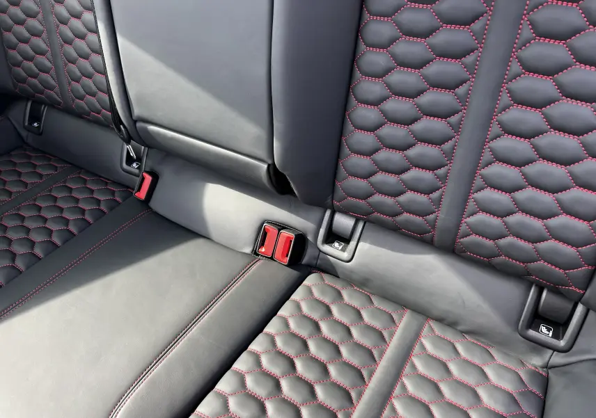 Détail des sièges arrière en cuir noir avec surpiqûres rouges en nid d'abeille de l'Audi RS3 Sportback 2022.