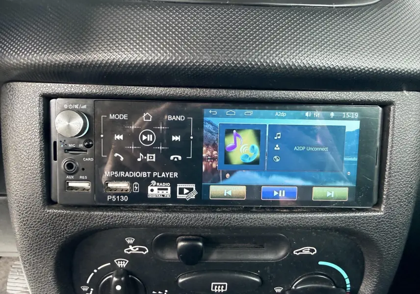 Gros plan sur l’autoradio MP5 avec écran tactile dans l’habitacle d’une Peugeot 206+ bleu.