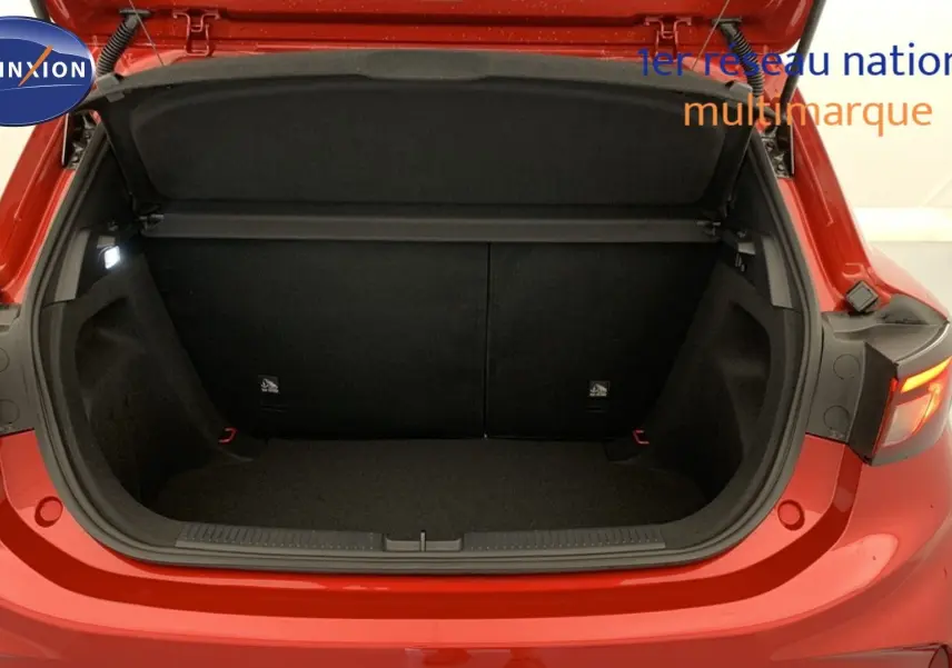 Coffre ouvert vu de l’arrière d’une MG3 1.5 L Hybrid+ 195 ch Luxury en rouge Diamond Red avec intérieur noir.