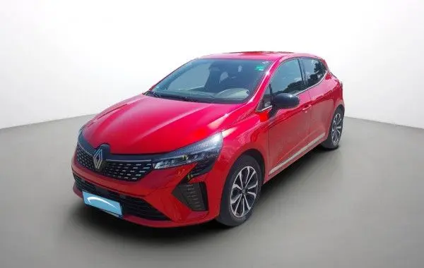 Renault Clio V E-Tech hybride rouge flamme, vue 3/4 avant droit, calandre noire et jantes alliage bicolores.