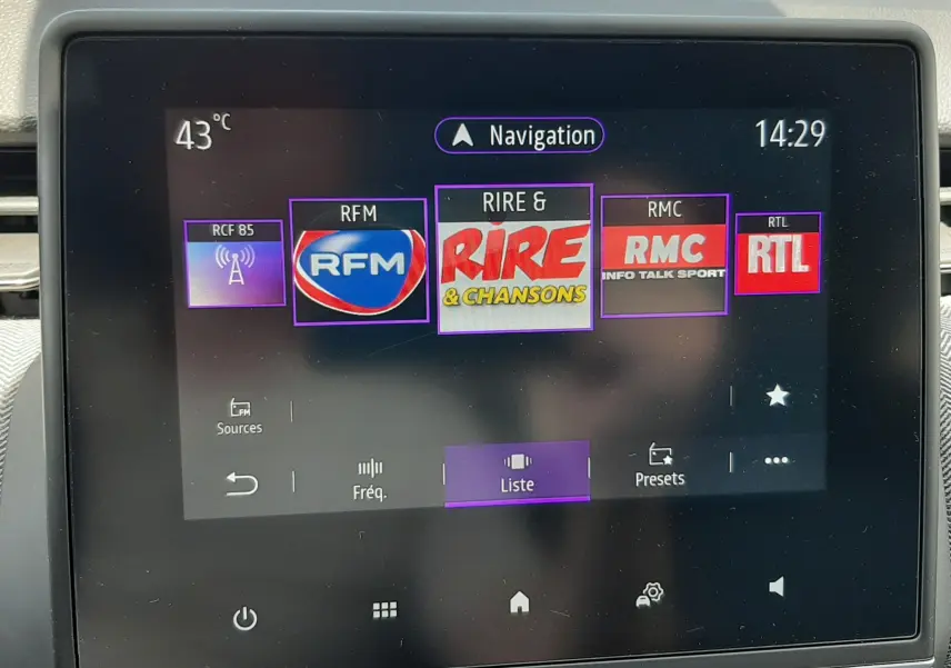 Écran tactile central de la Renault Clio V rouge flamme, affichant les stations radio avec interface moderne.
