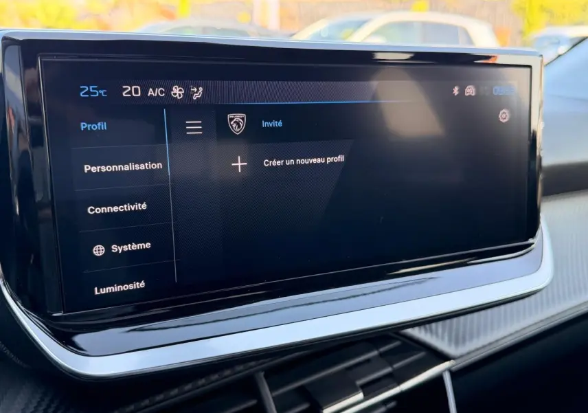 Écran tactile multifonction du tableau de bord de la Peugeot 208 1.2 100ch, affichant les options de profil utilisateur.