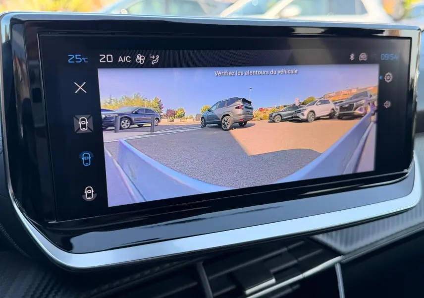 Écran tactile intérieur montrant la caméra de recul avec vue arrière sur plusieurs véhicules en stationnement.