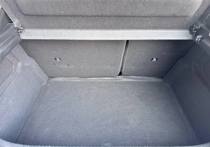 Coffre ouvert de la Peugeot 208 1.2 100ch gris Artense, vue intérieure montrant la banquette arrière rabattable.