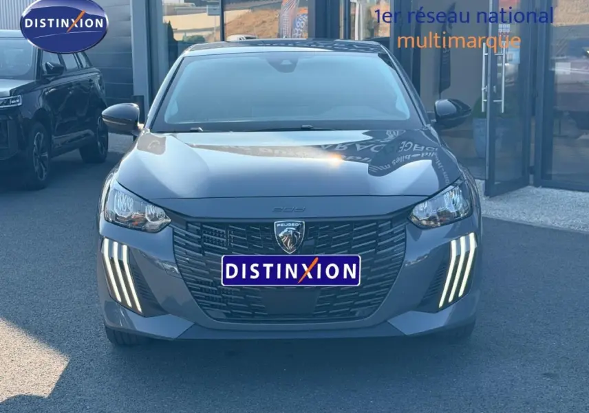 Vue de face d'une Peugeot 208 1.2 100ch S&S Allure gris Artense avec feux diurnes LED en griffes distinctives.