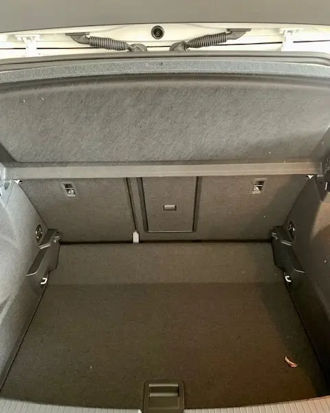 Coffre ouvert du Volkswagen T-Roc blanc 2021, vue intérieure montrant un espace de chargement propre et spacieux.