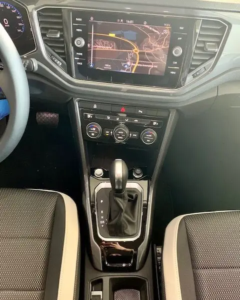 Vue rapprochée de la console centrale du Volkswagen T-Roc blanc 2021, avec écran GPS et levier de boîte automatique.