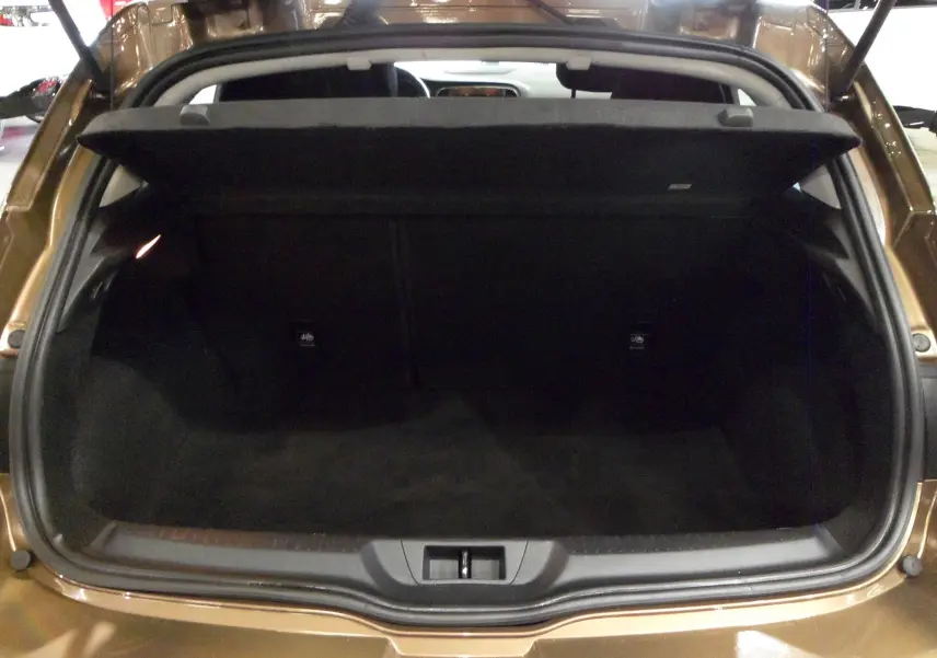 Coffre ouvert vu de l'arrière d'une Renault Mégane IV TCe 100 Life brun cappuccino, intérieur sombre et spacieux.