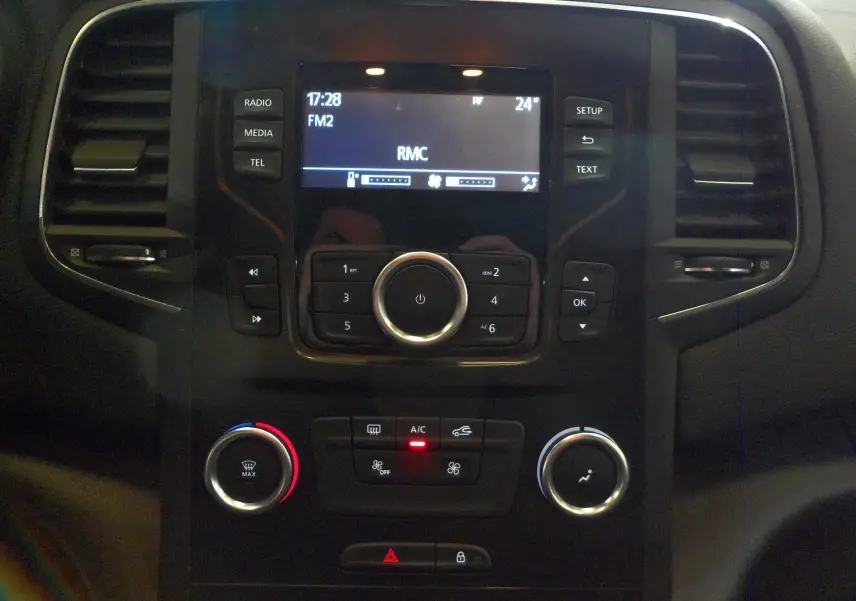 Tableau de bord central de Renault Mégane IV TCe 100 Life 2016, avec commandes radio et climatisation visibles.