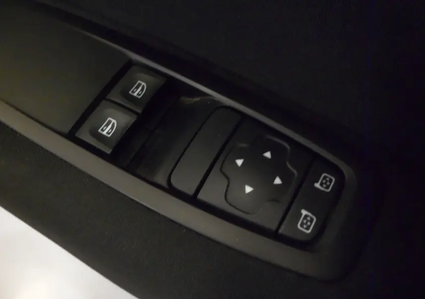 Gros plan sur les commandes électriques des vitres et rétroviseurs d'une Renault Mégane IV brun cappuccino, version TCe 100 CH LIFE.