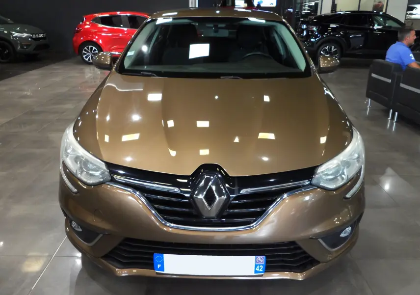 Vue frontale d'une Renault Mégane IV TCe 100 CH LIFE brun cappuccino, mettant en valeur sa calandre chromée et ses phares modernes.