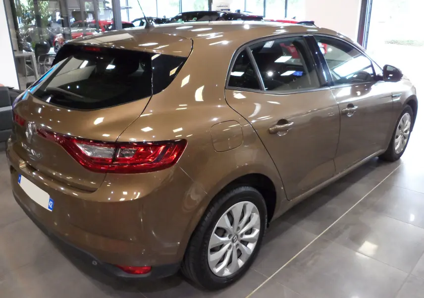 Vue 3/4 arrière droite d'une Renault Mégane IV brun cappuccino, avec feux arrière allongés et jantes alliage.